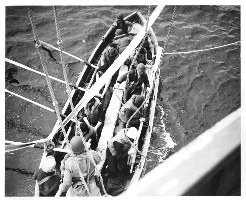 Official Caption: "OFF TO RESCUE THEIR BEATEN FOES: A pulling boat leaves the side of a Coast Guard combat cutter to rescue Nazi seamen struggling in the mid-Atlantic after their U-Boat had been blasted to the bottom by the cutter's depth charges. Two Coast Guard cutters brought 41 German survivors to a Scottish port." Date: 17 April 1943 Photo No.: 1516 Photographer: Jack January Description: The men in this pulling boat were in fact a trained boarding team led by LCDR John B. Oren (standing in the stern and wearing the OD helmet) and LT Ross Bullard (directly to Oren's left). With the assistance of the Royal Navy they had practiced boarding a submarine at sea in order to capture an Enigma coding machine and related intelligence material. They were forced to take a pulling lifeboat when the Spencer's motor lifeboat was damaged by friendly fire.