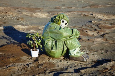 8205095-a-man-in-a-chemical-suit-and-a-houseplant-in-the-desert